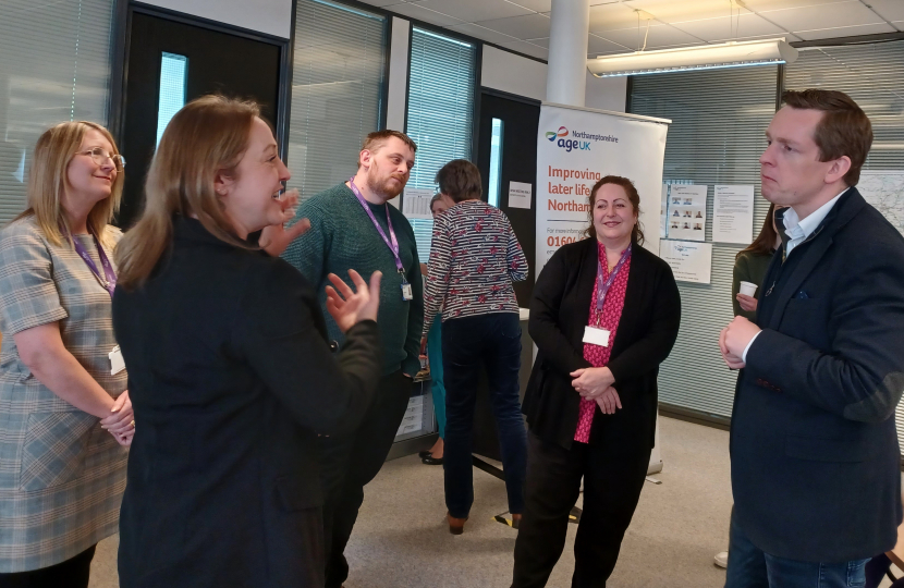 Tom in conversation with a group of representatives from Age UK Northamptonshire.